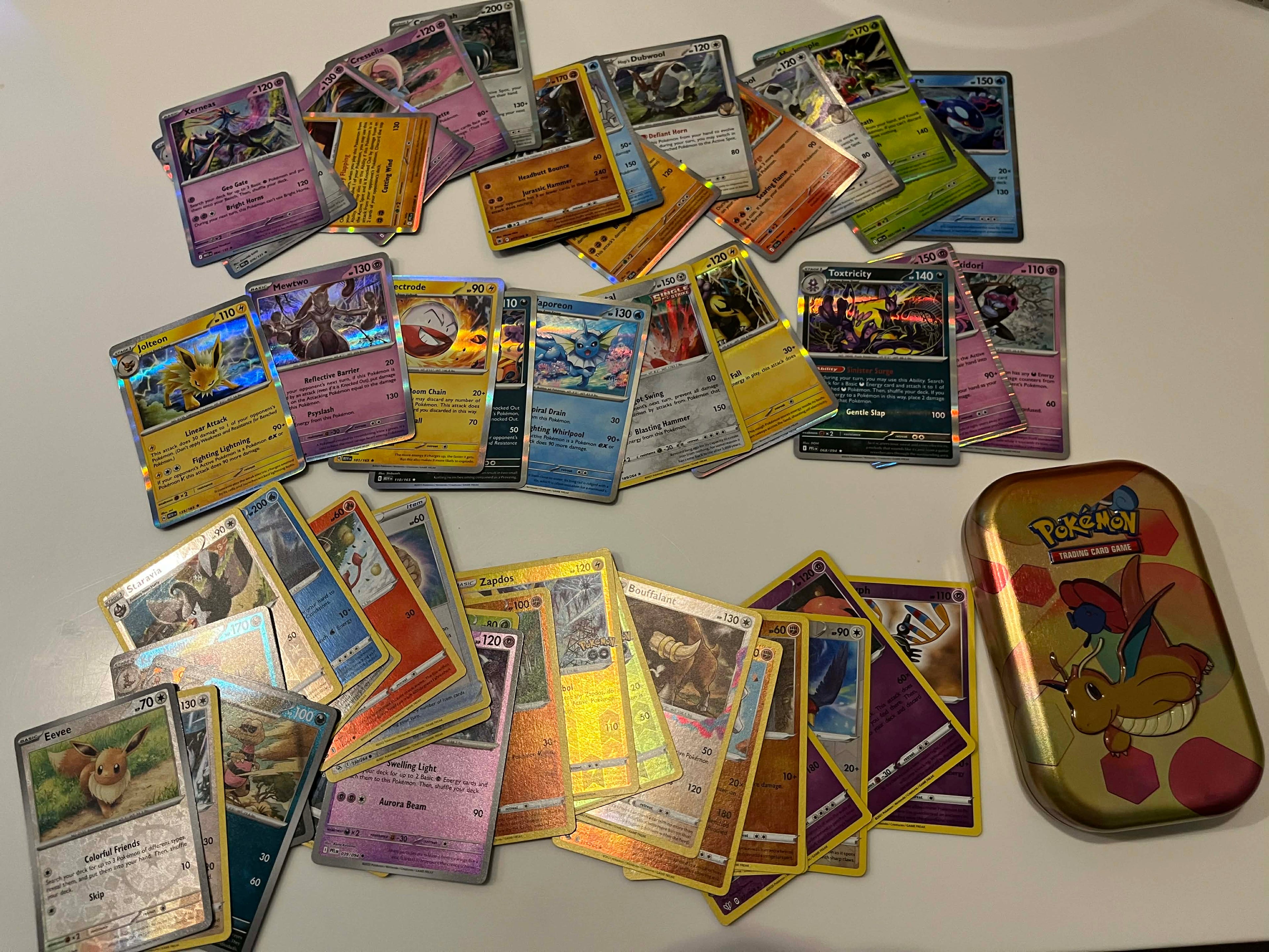 50 random Pokemon holos transported in a pokemon tin